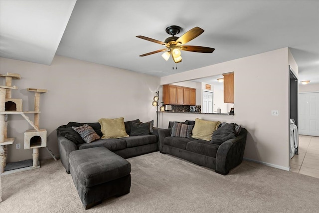 living area with light carpet and ceiling fan