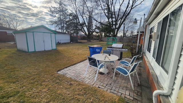 view of patio / terrace with a storage unit, a fenced backyard, an outdoor structure, and grilling area