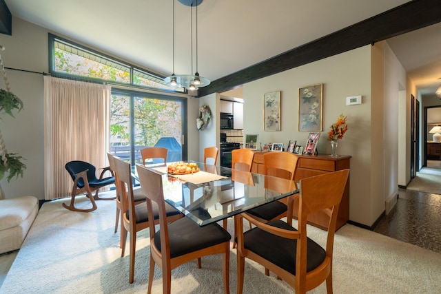 carpeted dining area featuring beamed ceiling