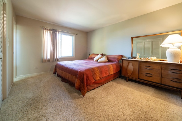 bedroom with light colored carpet and baseboards