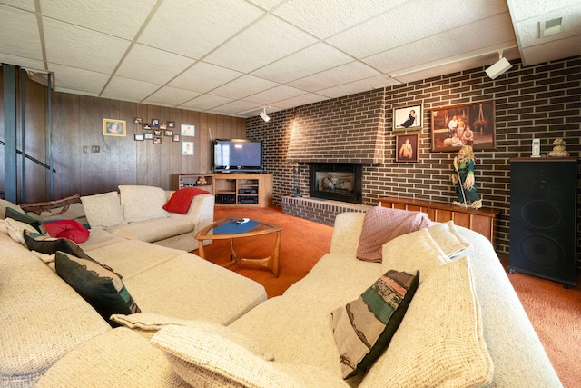 living room with rail lighting, a fireplace, a drop ceiling, and carpet floors