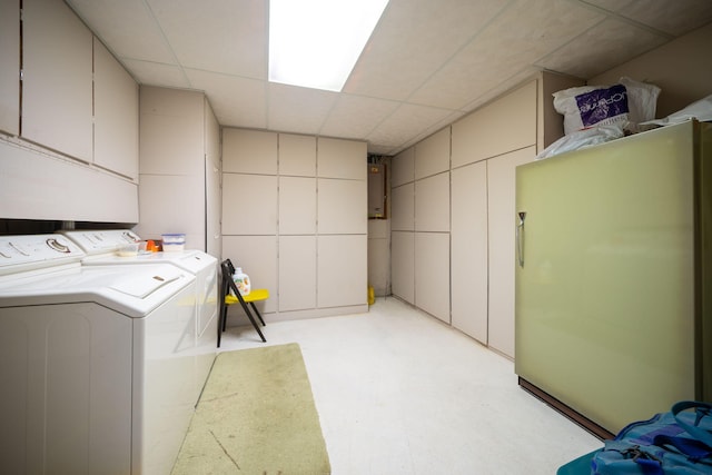 clothes washing area featuring electric panel, cabinet space, and washing machine and clothes dryer