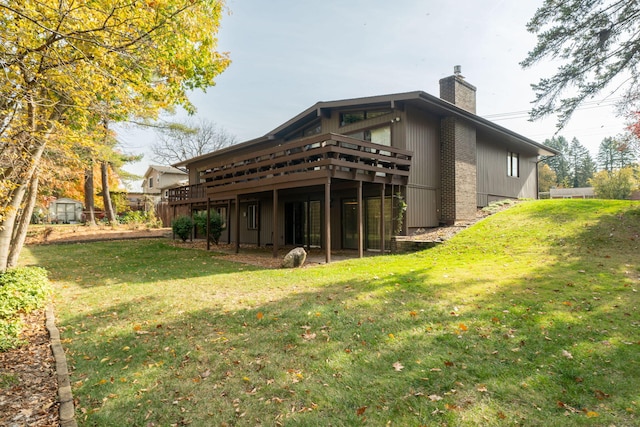 rear view of house with a deck, a lawn, and a chimney