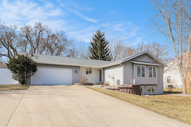 view of front of property with driveway, a front yard, roof with shingles, and an attached garage