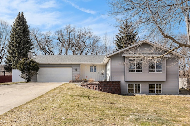 tri-level home featuring a garage, concrete driveway, and a front lawn