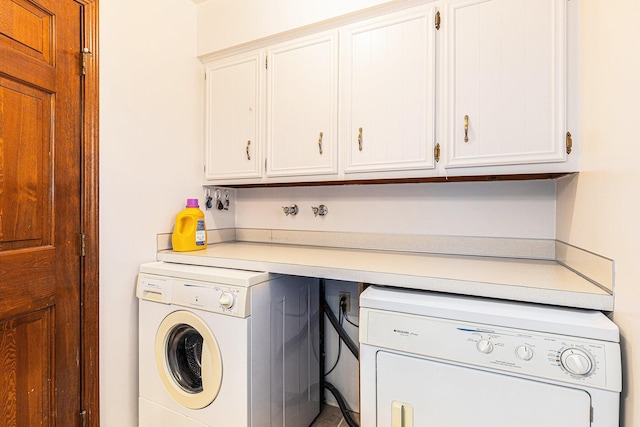 laundry room featuring washing machine and dryer and cabinet space