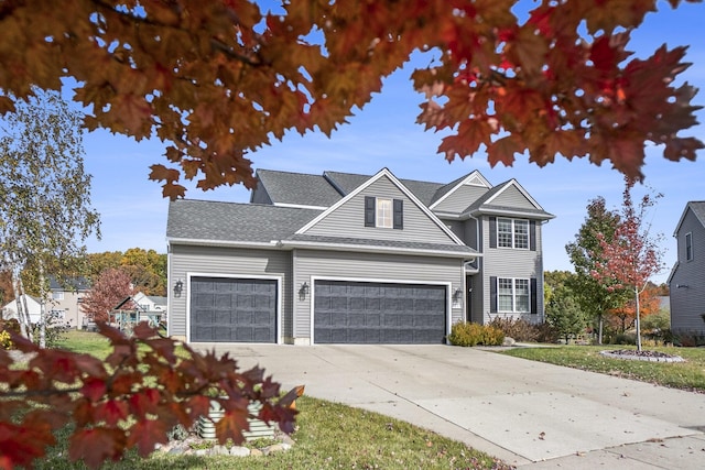 traditional-style house featuring concrete driveway, a garage, and roof with shingles