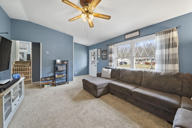 carpeted living area with ceiling fan and vaulted ceiling