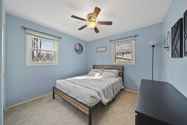 bedroom featuring baseboards, light colored carpet, and ceiling fan