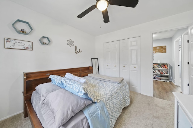 bedroom with a closet, light carpet, baseboards, and a ceiling fan