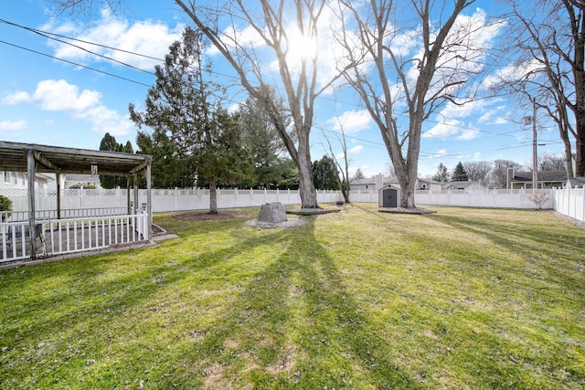 view of yard featuring a storage shed, an outbuilding, and a fenced backyard