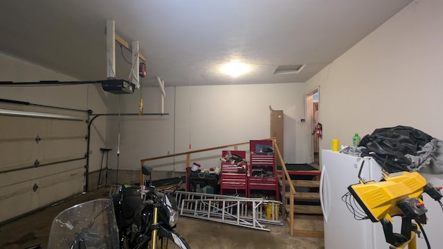 garage with a garage door opener and freestanding refrigerator