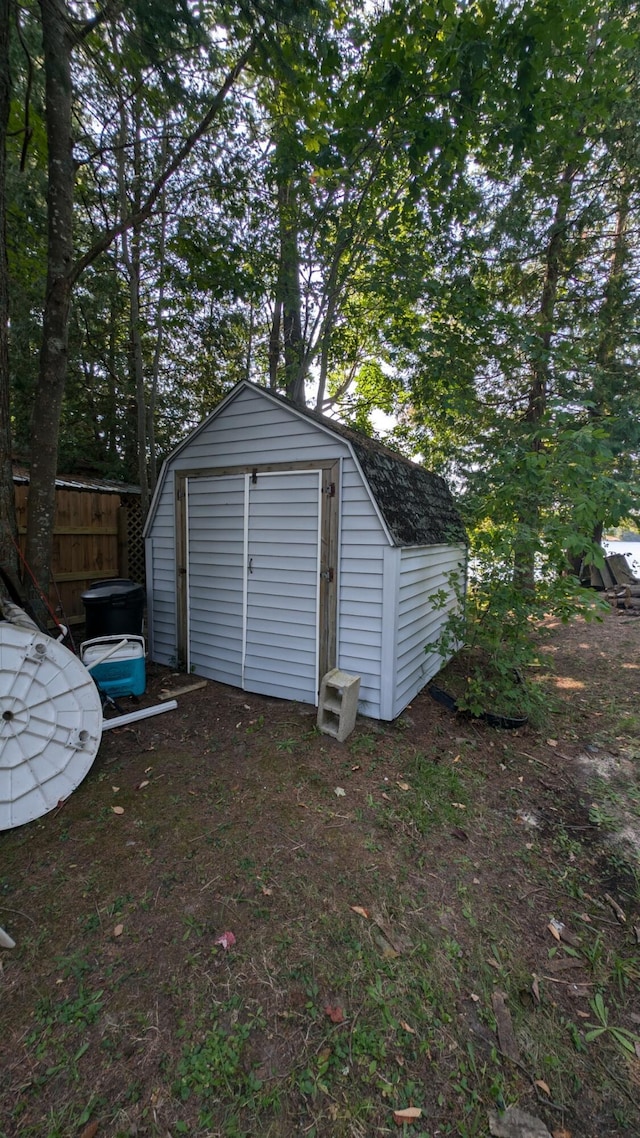 garage featuring a shed and fence