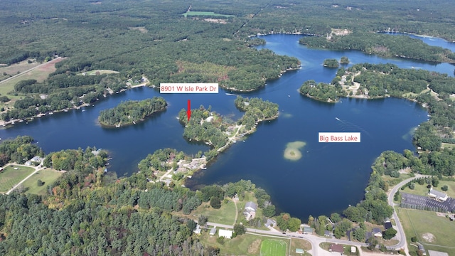 birds eye view of property featuring a forest view and a water view