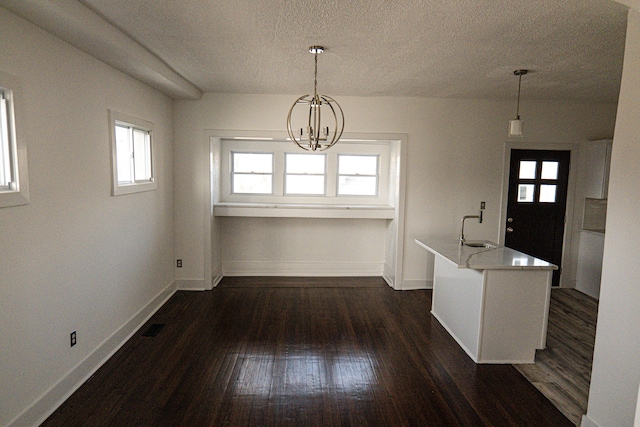 2552 N La Salle Gdns, Detroit, MI 48206 - unfurnished dining area with a textured ceiling, a notable chandelier, dark wood-style floors, and a sink