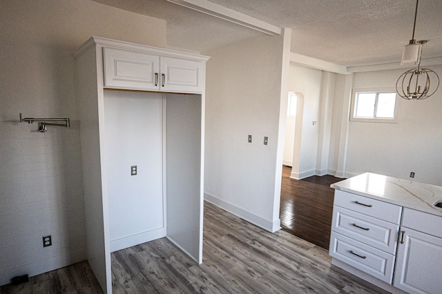 2552 N La Salle Gdns, Detroit, MI 48206 - kitchen with pendant lighting, a textured ceiling, white cabinetry, arched walkways, and dark wood-style flooring