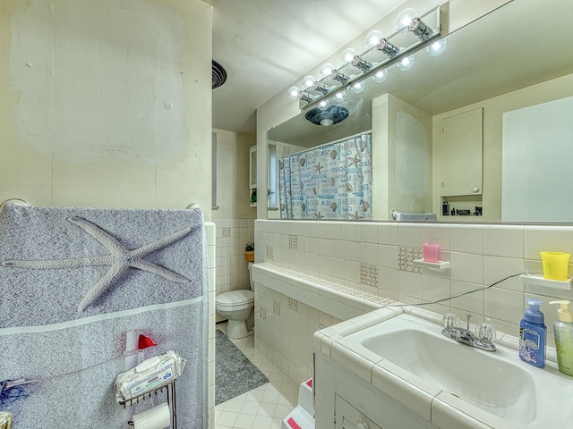 full bathroom with tile patterned floors, a shower with curtain, toilet, tile walls, and vanity