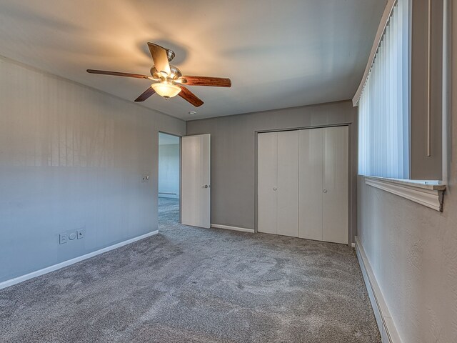 unfurnished bedroom featuring a closet, baseboards, carpet, and a ceiling fan