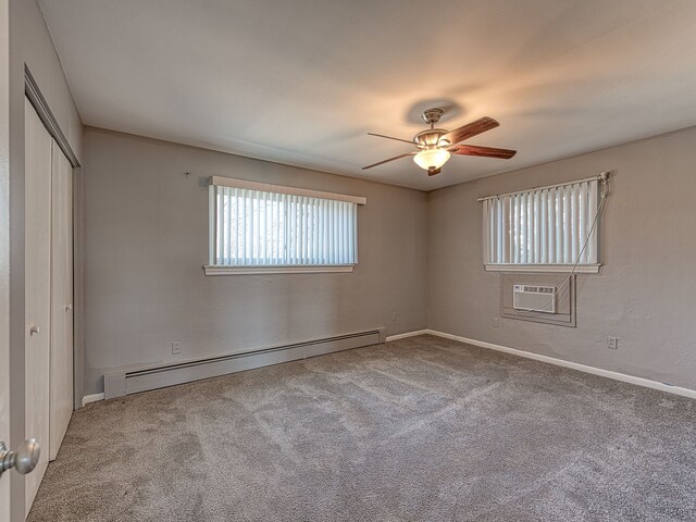 unfurnished bedroom featuring a ceiling fan, carpet, an AC wall unit, a closet, and baseboard heating