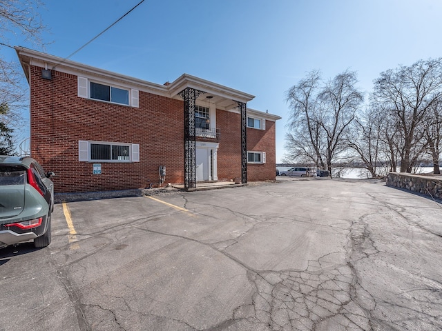 view of front of property featuring uncovered parking and brick siding