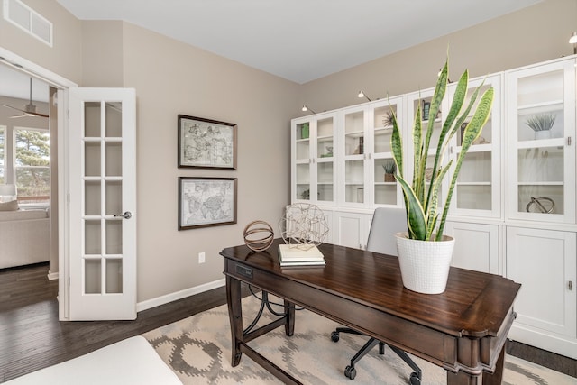 office space featuring visible vents, a ceiling fan, baseboards, and wood finished floors