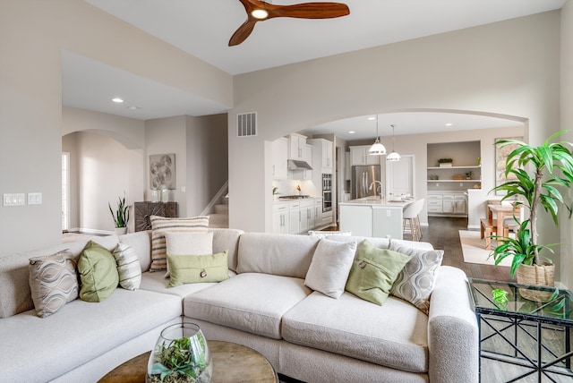 living area with visible vents, built in shelves, a ceiling fan, recessed lighting, and dark wood-style flooring