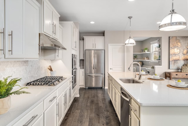 kitchen with under cabinet range hood, light countertops, appliances with stainless steel finishes, white cabinets, and a sink