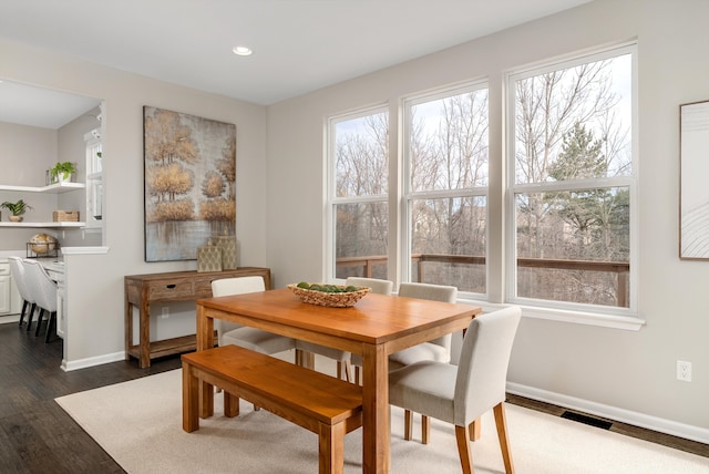 dining space with dark wood finished floors, recessed lighting, a healthy amount of sunlight, and baseboards