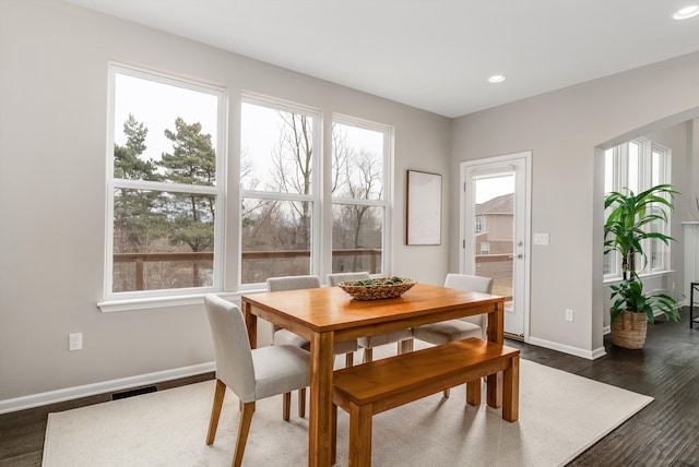 dining room featuring baseboards, visible vents, dark wood finished floors, recessed lighting, and arched walkways