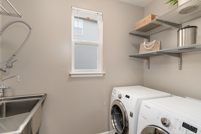 laundry area with laundry area, separate washer and dryer, and a sink