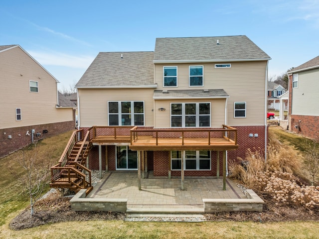 back of property featuring stairway, a patio, brick siding, and a deck