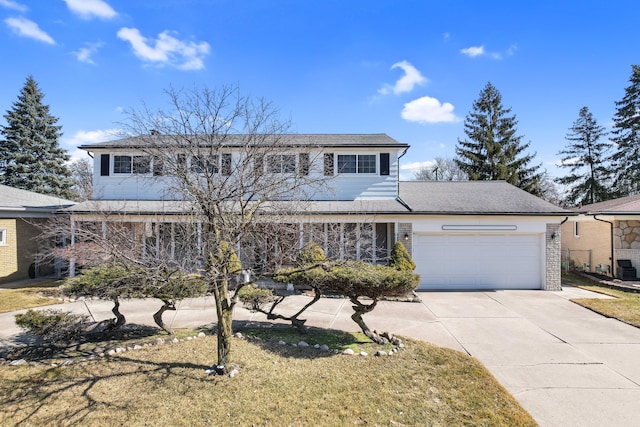 traditional-style home with brick siding, an attached garage, and concrete driveway