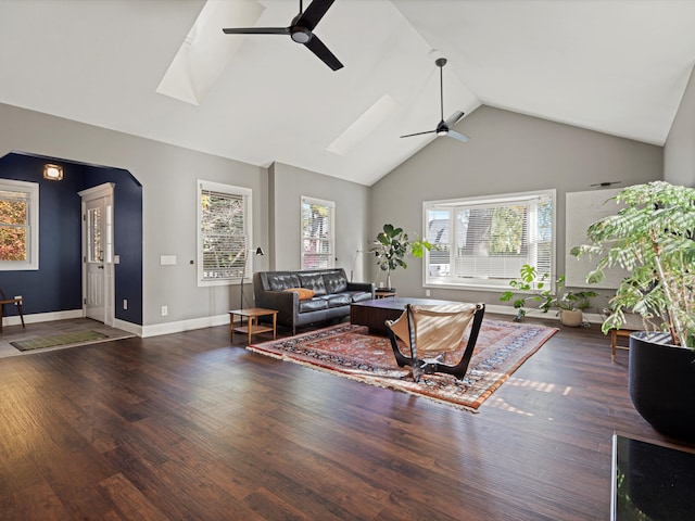 living room featuring a skylight, wood finished floors, high vaulted ceiling, and ceiling fan