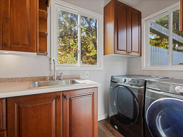 clothes washing area featuring a sink, cabinet space, dark wood-style flooring, and washing machine and clothes dryer