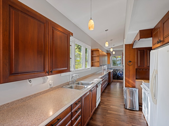 kitchen featuring white appliances, a sink, hanging light fixtures, light countertops, and washer and clothes dryer