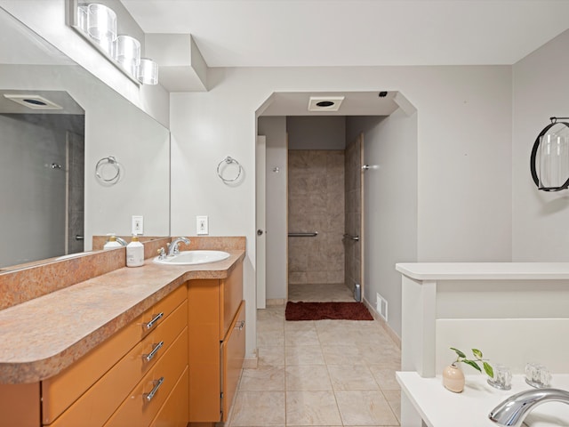 full bathroom with vanity, tile patterned floors, visible vents, and tiled shower