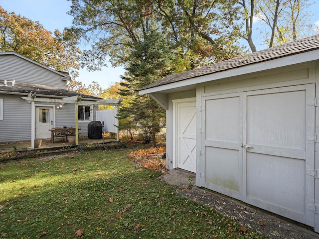 view of yard with an outdoor structure, a storage unit, and a patio area