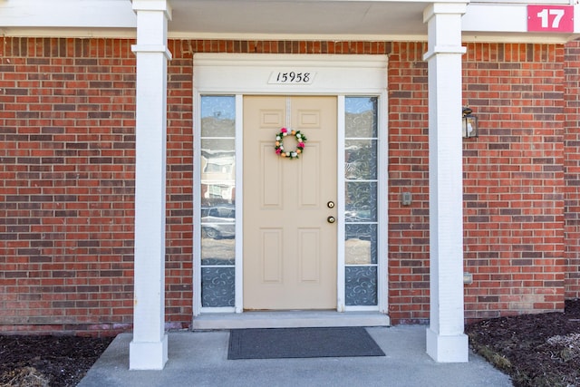 doorway to property featuring brick siding