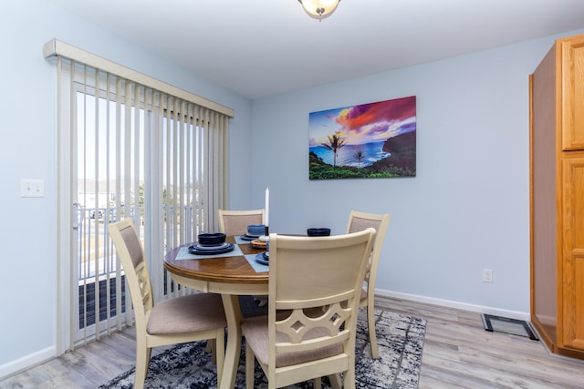 dining area with baseboards and light wood-style floors