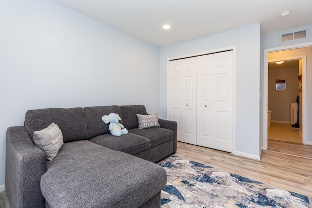 living room featuring recessed lighting, visible vents, light wood-type flooring, and baseboards