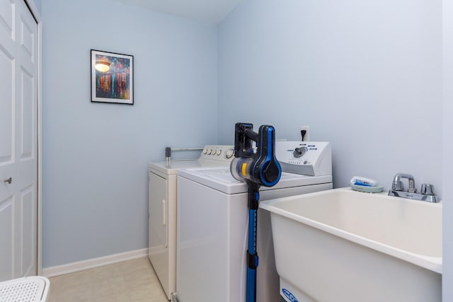 washroom featuring a sink, baseboards, independent washer and dryer, and laundry area