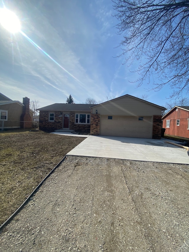 single story home featuring stone siding, fence, a garage, and dirt driveway