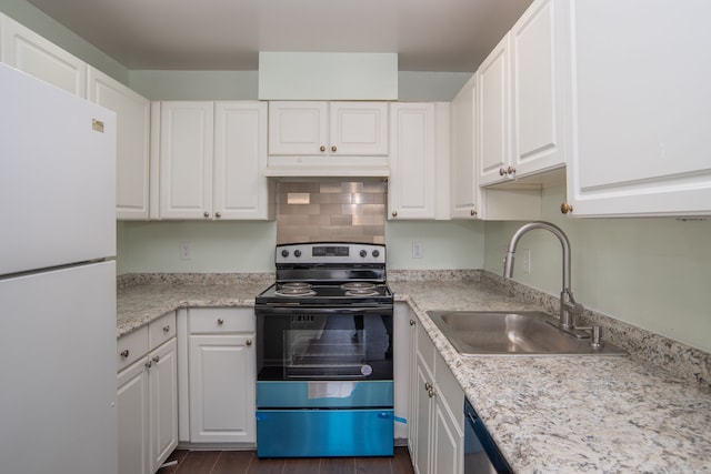 kitchen featuring under cabinet range hood, a sink, range with electric stovetop, freestanding refrigerator, and white cabinets