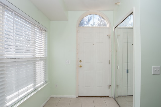 foyer entrance with light tile patterned flooring and baseboards