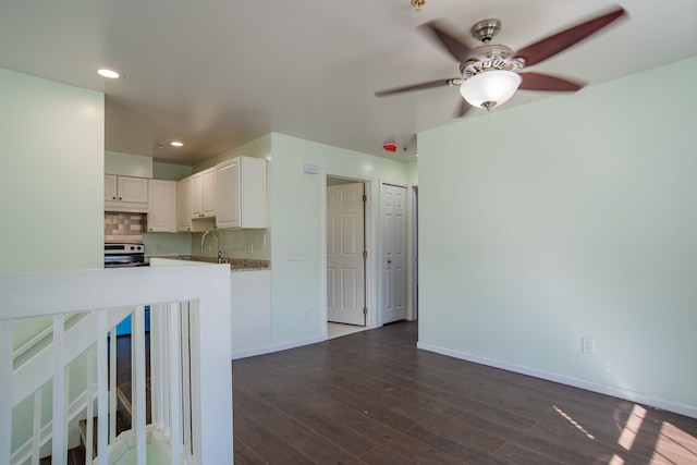 kitchen featuring baseboards, dark wood finished floors, electric range, white cabinetry, and backsplash