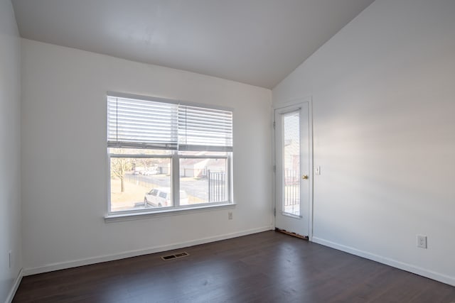 unfurnished room featuring visible vents, baseboards, dark wood-type flooring, and lofted ceiling