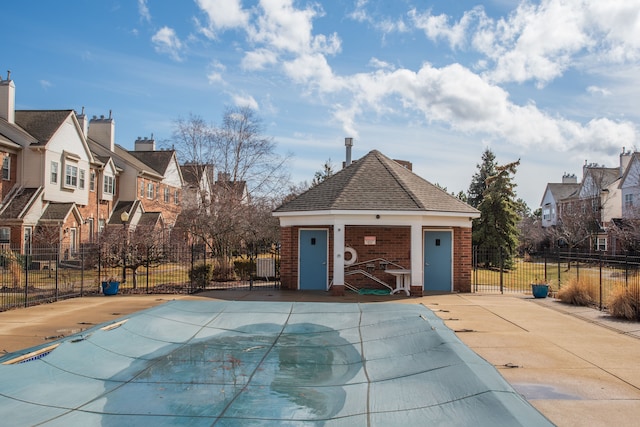 view of swimming pool with an outbuilding, a residential view, a patio area, and fence