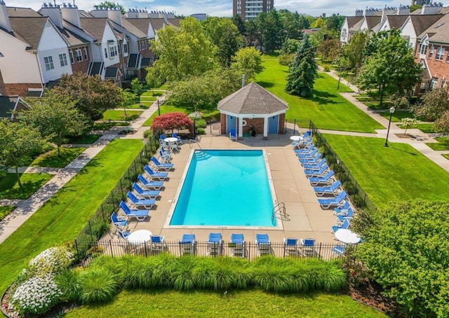 pool featuring a residential view, a patio, an outdoor structure, and fence