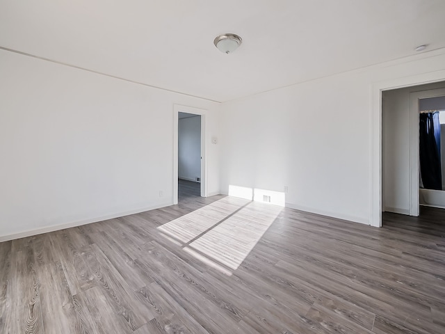 empty room with baseboards and wood finished floors