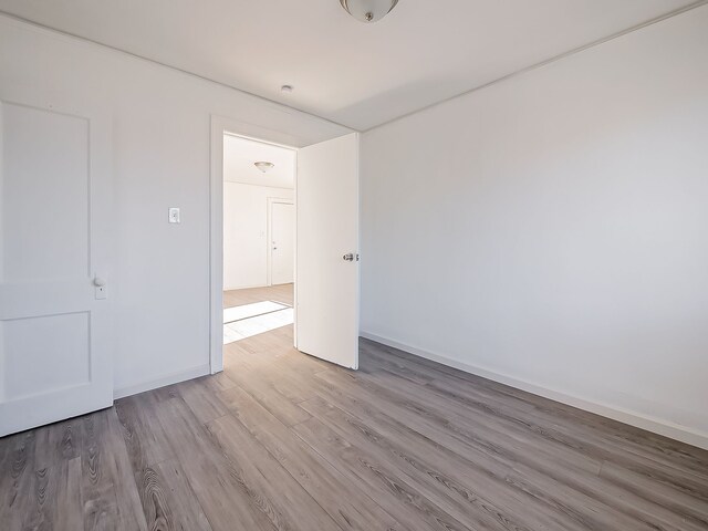 unfurnished room featuring baseboards and wood finished floors